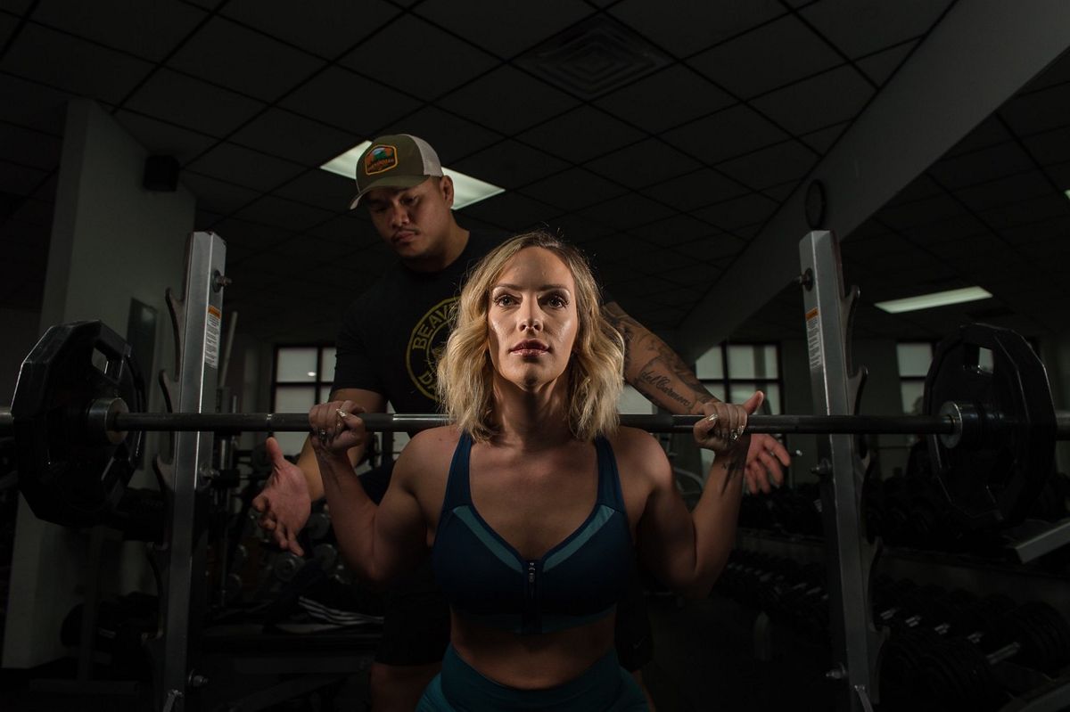 Delcarmen spotting a female client's squat